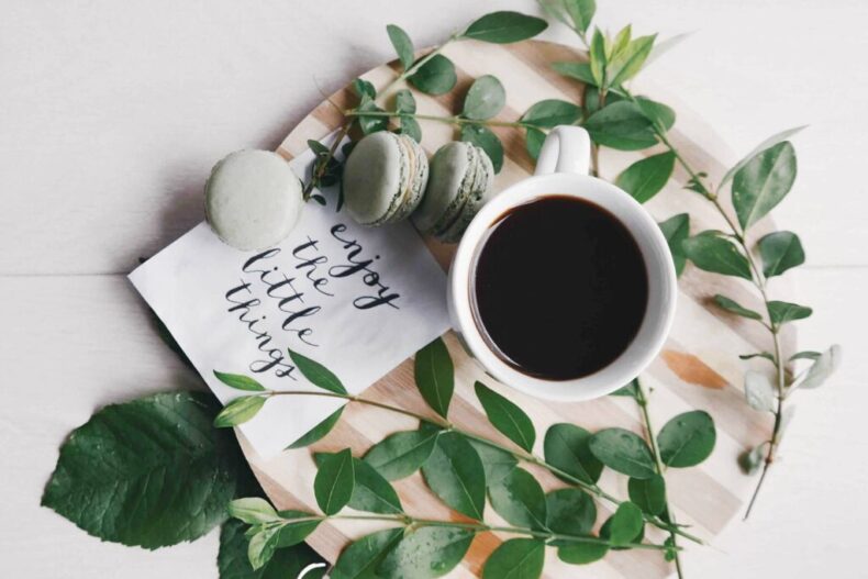 Top view coffee and green macarons with note