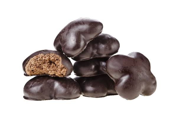 Chocolate-covered gingerbread cookies with one broken to show the texture.
